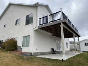 Back of property with a yard and a patio