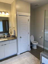 Bathroom with hardwood / wood-style flooring, vanity, and toilet