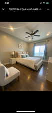 Bedroom with dark hardwood / wood-style floors and ceiling fan