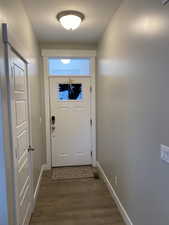 Doorway to outside with dark hardwood / wood-style flooring
