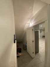 Interior space featuring tile patterned floors and vaulted ceiling