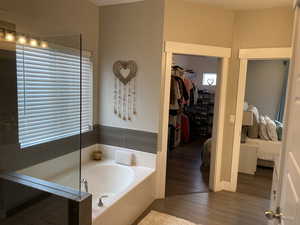 Bathroom featuring hardwood / wood-style floors and tiled bath