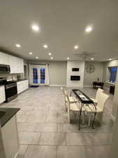 Tiled living room with a large fireplace and french doors