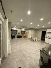 Tiled living room with ceiling fan and sink