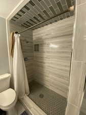 Bathroom with toilet and a shower with shower curtain