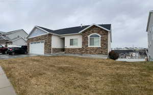 View of front of house with a garage and a front lawn
