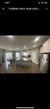 Kitchen featuring stainless steel refrigerator, white cabinetry, and dark wood-type flooring