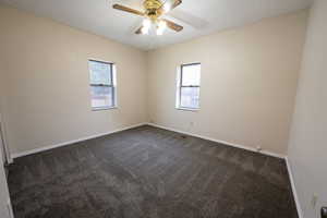 Carpeted spare room with ceiling fan and a textured ceiling