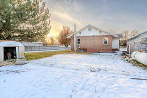 Snow covered property with a storage shed