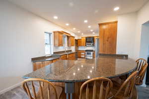 Kitchen with kitchen peninsula, sink, stainless steel appliances, and wood-type flooring