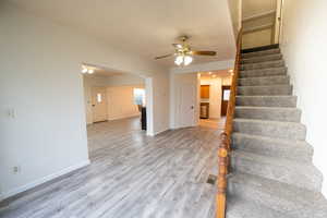 Staircase with wood-type flooring and ceiling fan