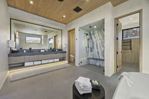 Bathroom featuring vanity, independent shower and bath, wooden ceiling, and a wealth of natural light