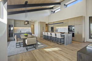 Dining room featuring beam ceiling, light wood-type flooring, wood ceiling, and high vaulted ceiling