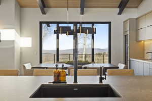 Kitchen with a mountain view, sink, beamed ceiling, and wooden ceiling