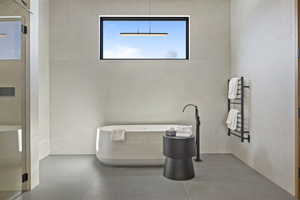 Bathroom featuring concrete flooring and a tub to relax in