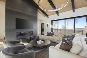 Living room with beam ceiling, hardwood / wood-style floors, high vaulted ceiling, and wooden ceiling