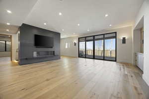 Unfurnished living room with a large fireplace and light hardwood / wood-style flooring