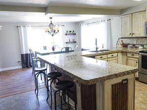 Kitchen with a kitchen bar, sink, hanging light fixtures, and an inviting chandelier