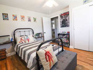 Bedroom with hardwood / wood-style floors and ceiling fan