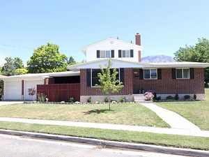 View of front of house featuring a mountain view, a garage, and a front yard