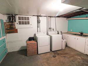 Washroom with washer and dryer, sink, and cabinets