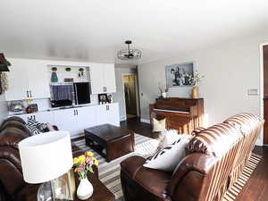 Living room featuring wood-type flooring and an inviting chandelier