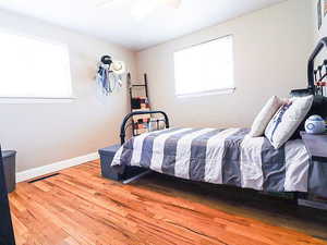 Bedroom with hardwood / wood-style floors and ceiling fan