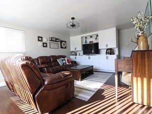 Living room with an inviting chandelier and dark wood-type flooring