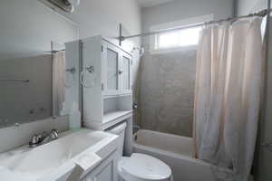 Full bathroom with vanity, toilet, and shower / bath combo with shower curtain