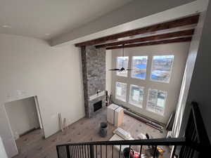 Living room with beam ceiling, a fireplace, and ceiling fan