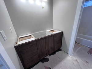 Bathroom featuring concrete flooring and a tub