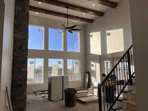 Living room featuring ceiling fan and beam ceiling