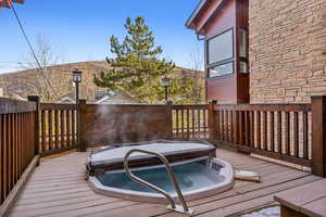 Wooden terrace featuring a covered hot tub