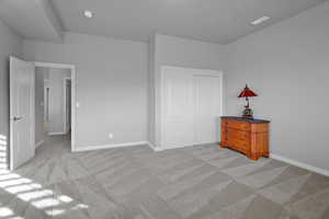 Bedroom with light carpet and a closet