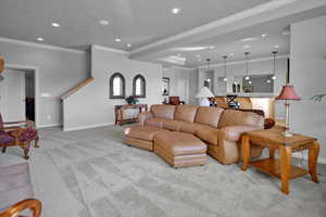 Living room featuring crown molding and light colored carpet