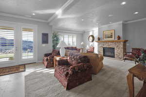 Carpeted living room featuring crown molding, a fireplace, and a textured ceiling