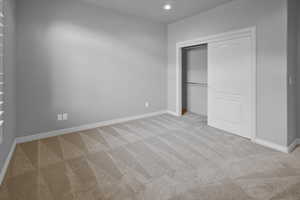 Unfurnished bedroom with a closet and light colored carpet