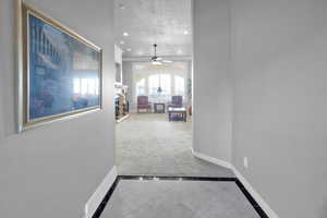 Corridor with tile patterned flooring and a textured ceiling