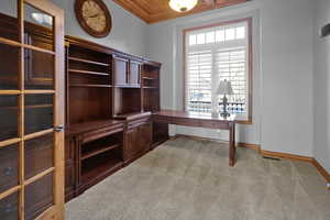 Home office featuring light carpet, ornamental molding, and wood ceiling