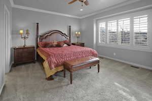 Bedroom featuring carpet, ceiling fan, and crown molding