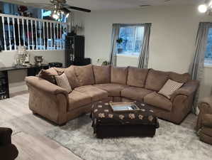 Living room with ceiling fan and light hardwood / wood-style flooring