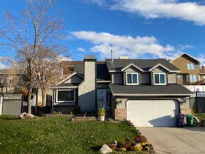 View of front of house featuring a garage and a front lawn