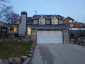 View of front of property featuring a yard and a garage