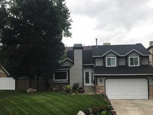 View of front of home with a garage and a front lawn