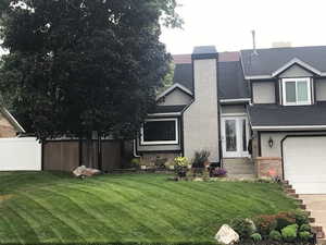 View of front of property featuring a front lawn and a garage