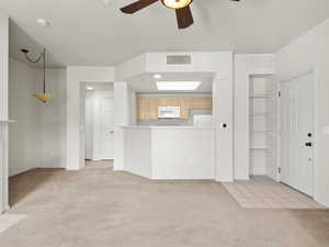 Unfurnished living room with ceiling fan and light carpet