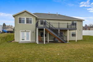 Rear view of house with french doors, a yard, a deck, and a patio area