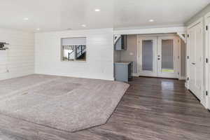 Interior space featuring french doors, dark hardwood / wood-style floors, and wooden walls