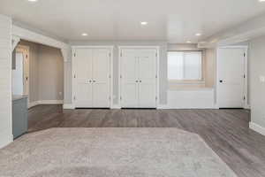 Unfurnished bedroom featuring two closets and dark wood-type flooring