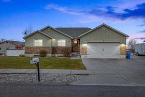 Ranch-style home with a garage and a yard